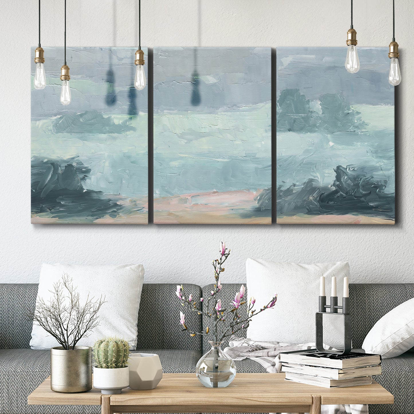 Three-panel canvas wall art featuring soft pastel valley landscape, displayed in a modern living room above seating.