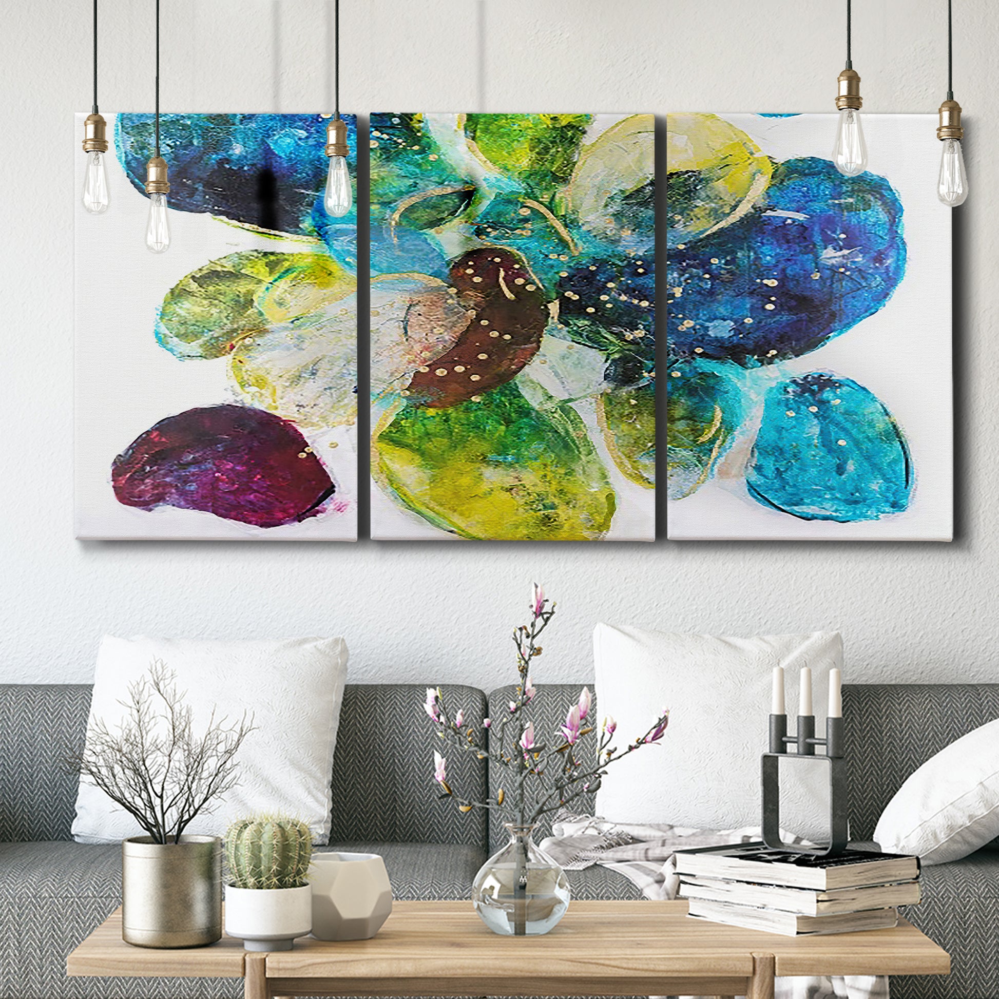 Three-panel canvas wall art featuring expressive abstract color interpretations, displayed in a modern living room above seating.