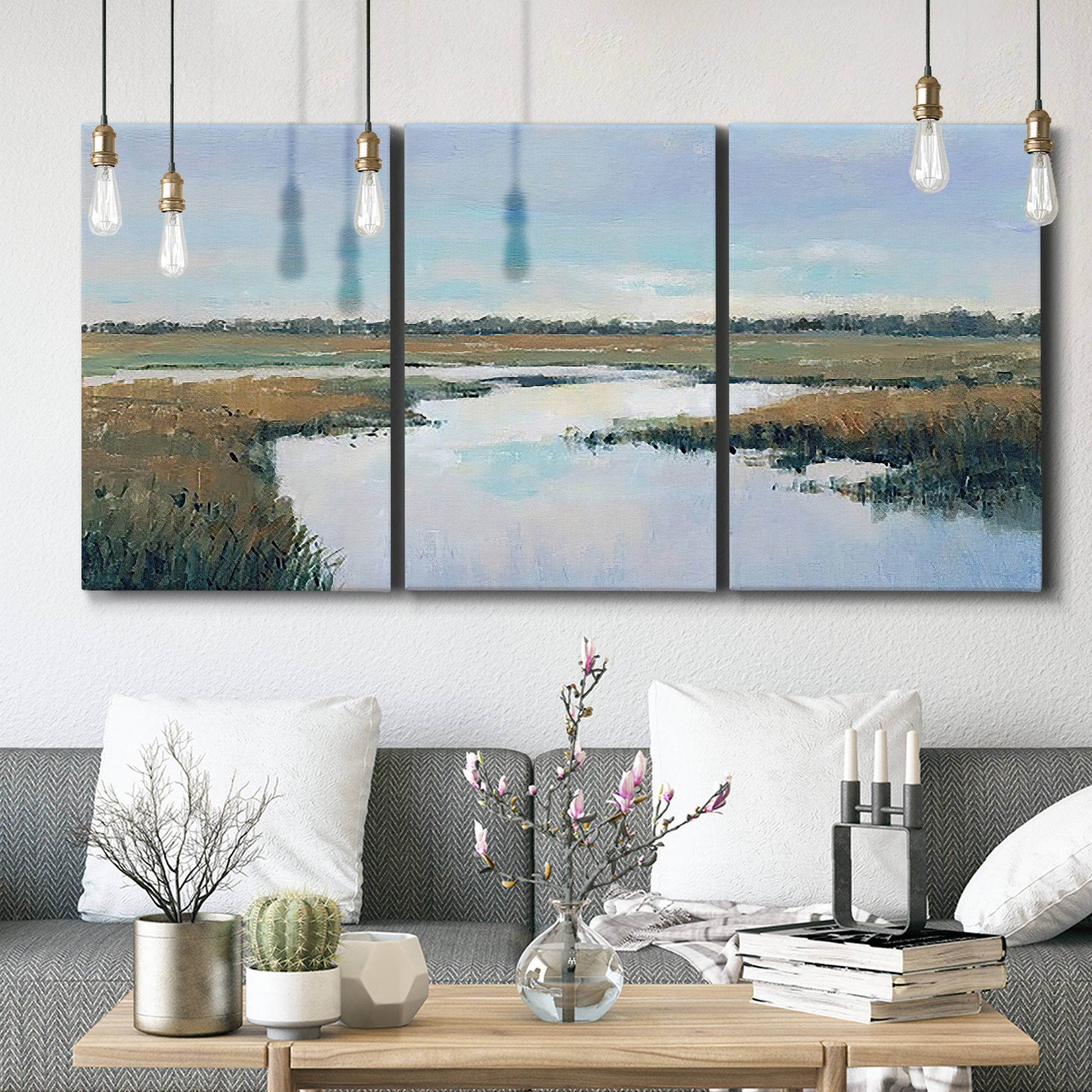 Three-panel canvas wall art featuring coastal plain meeting open water, displayed in a modern living room above seating.