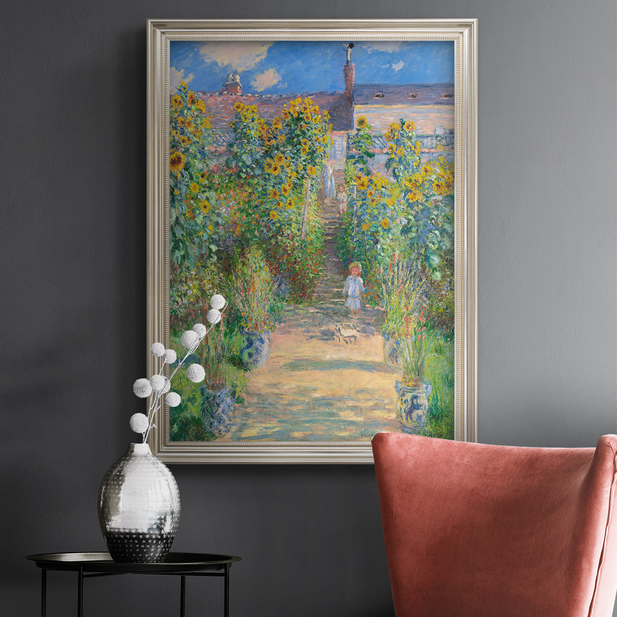 Impressionist garden landscape painting by Claude Monet in an ornate champagne frame displayed in a dark-toned interior setting.