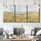 Three-panel canvas wall art featuring pastoral wheat field landscape, displayed in a modern living room above seating.