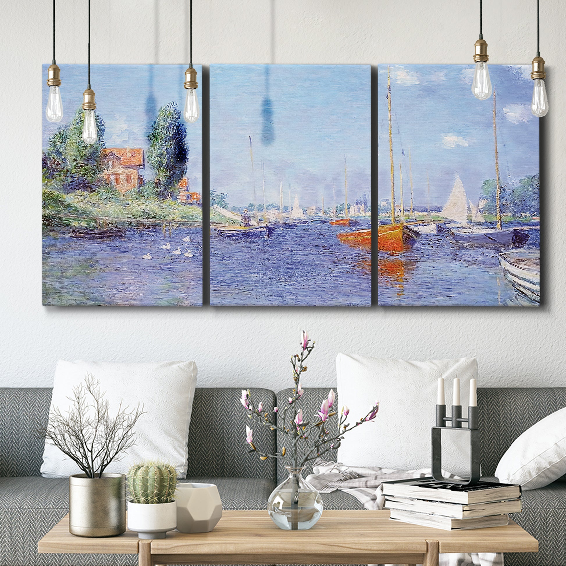 Three-panel canvas wall art featuring river flowing past riverside town, displayed in a modern living room above seating.