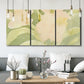 Three-panel canvas wall art featuring minimal verdant floral abstraction, displayed in a modern living room above seating.