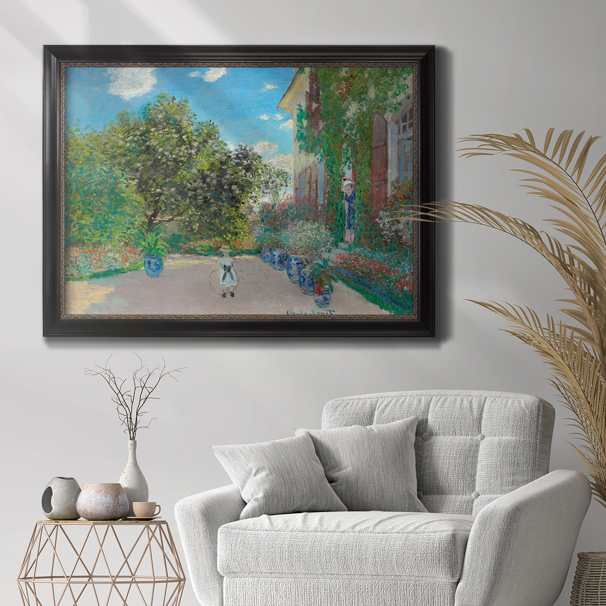 Impressionist residential landscape at Argenteuil by Claude Monet in an ornate black frame with gilded inner detail displayed in a bright interior setting.