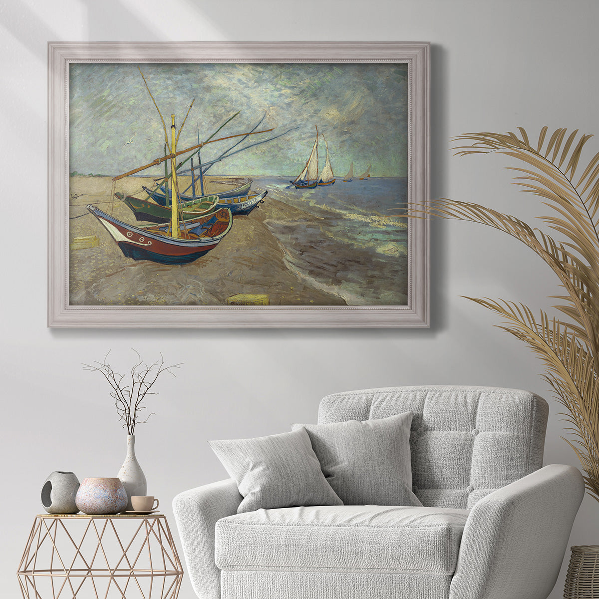 Impressionist coastal fishing boats scene by Vincent van Gogh in an ornate weathered white frame displayed in a bright interior setting.