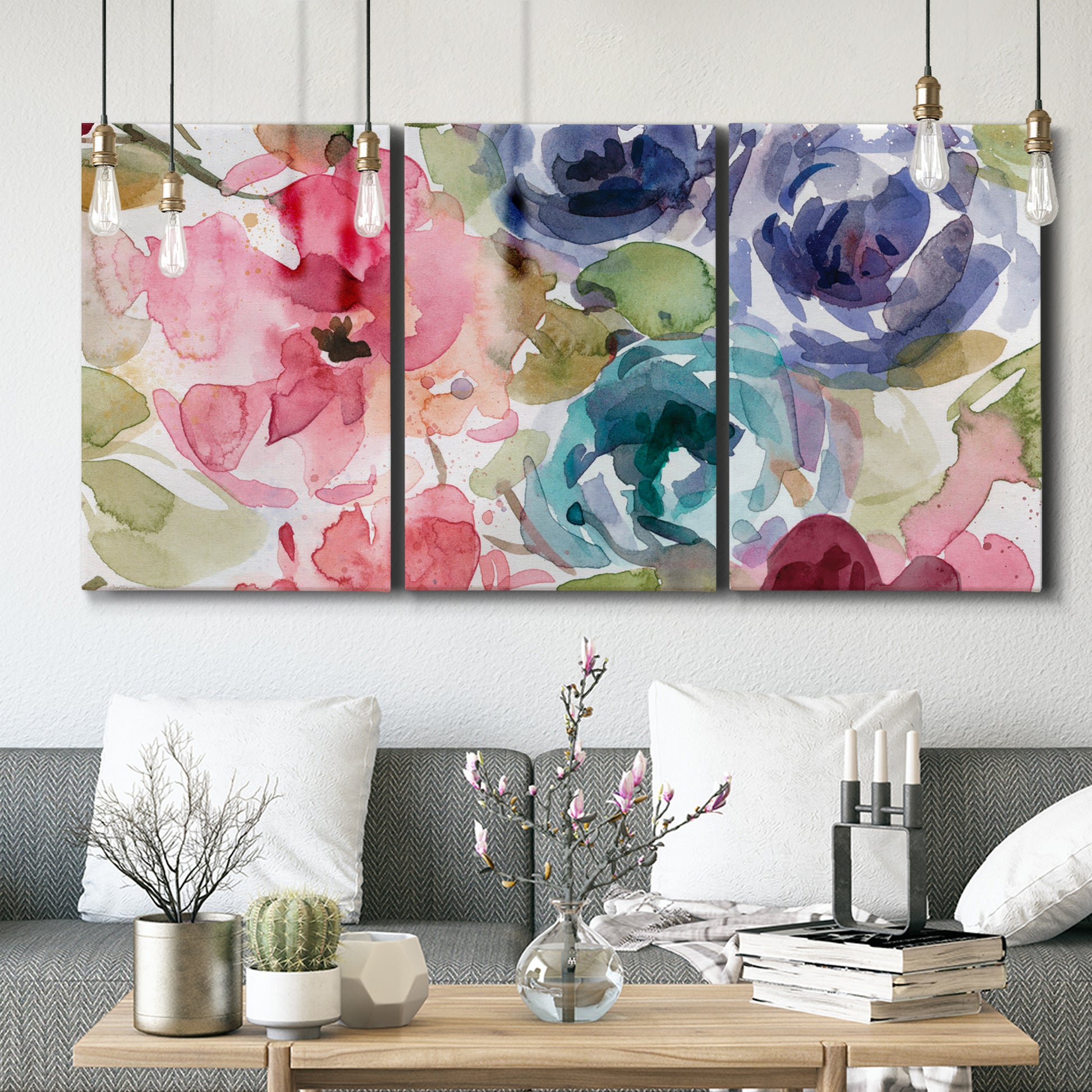 Three-panel canvas wall art featuring soft floral watercolor composition, displayed in a modern living room above seating.