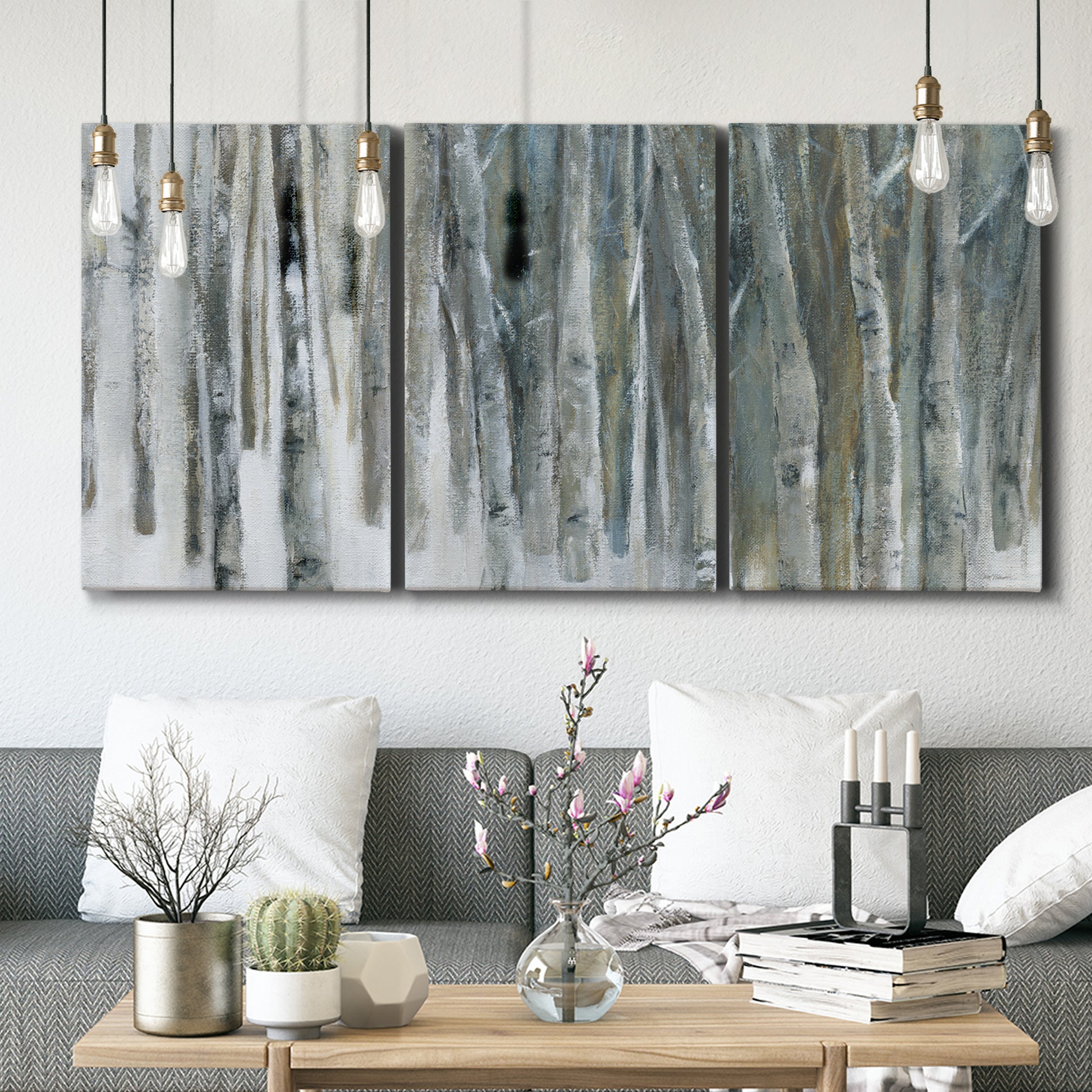 Three-panel canvas wall art featuring abstract birch forest landscape, displayed in a modern living room above seating.