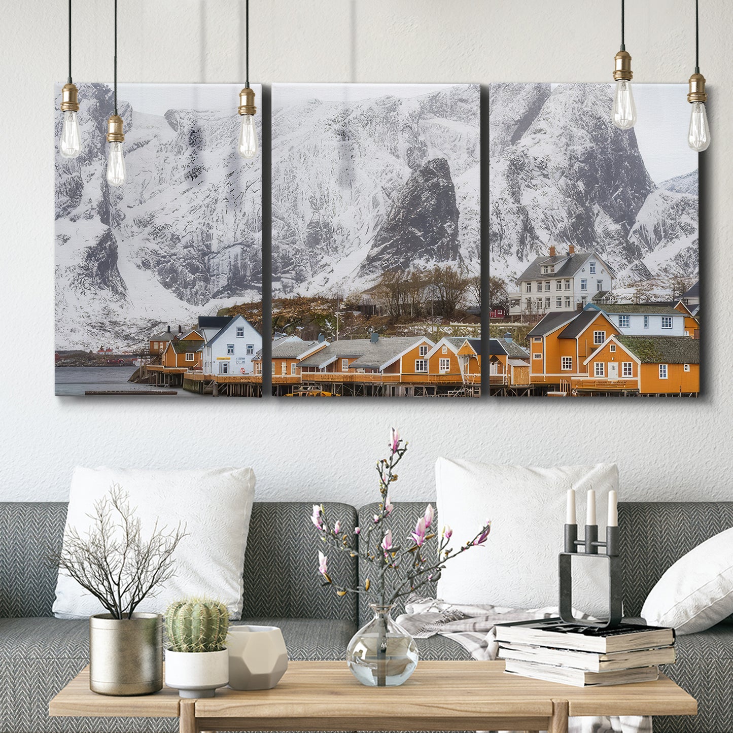 Three-panel canvas wall art featuring winter village street photography, displayed in a modern living room above seating.