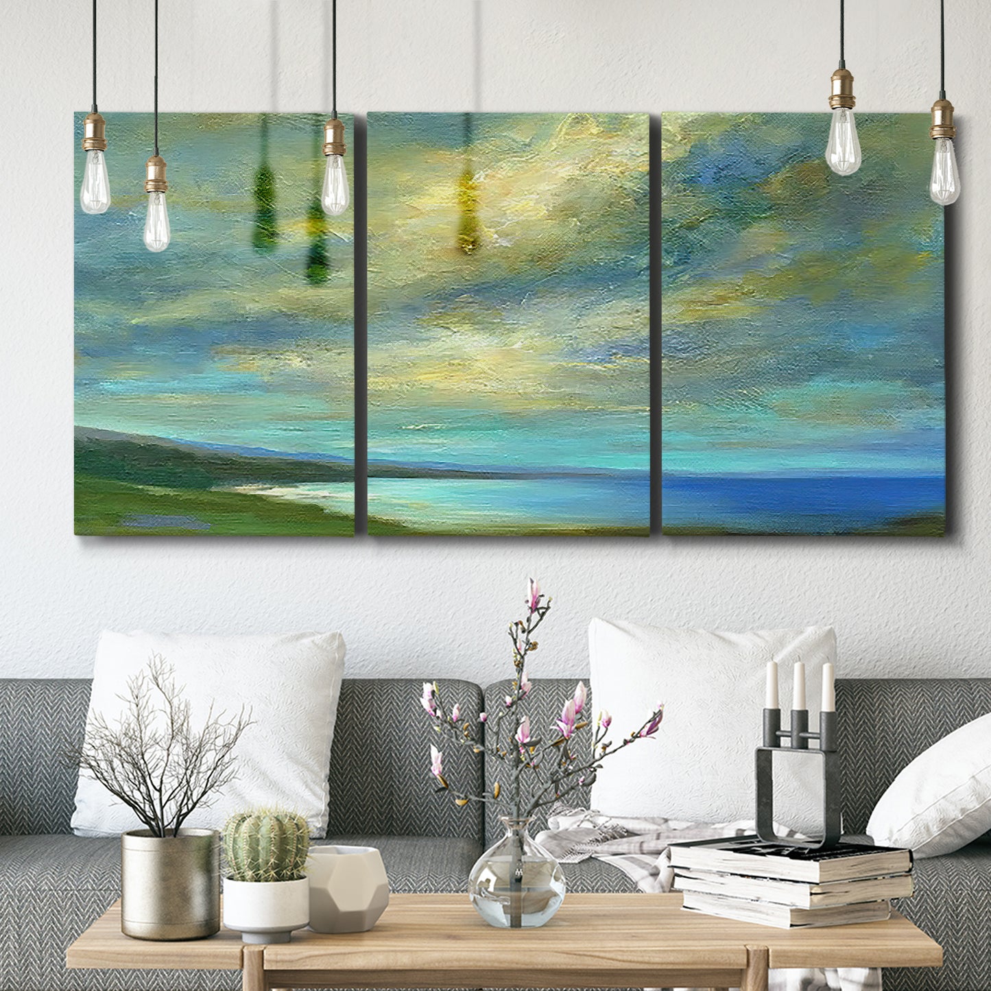 Three-panel canvas wall art featuring coastal shoreline with soft waves, displayed in a modern living room above seating.