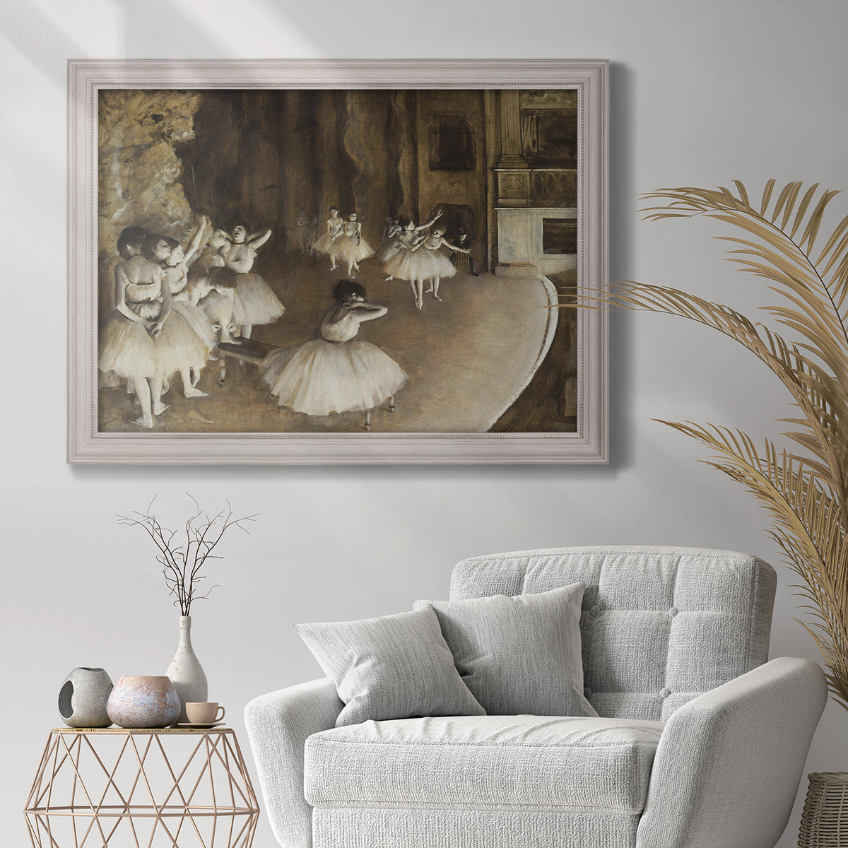 Impressionist ballet rehearsal scene by Edgar Degas in an ornate weathered white frame displayed in a bright interior setting.