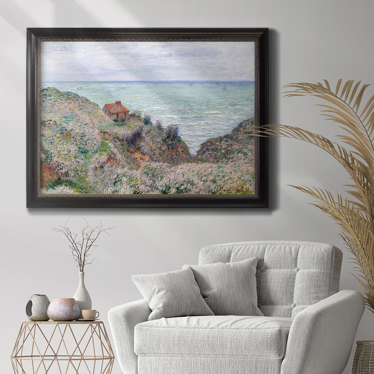 Impressionist coastal watch cabin scene by Claude Monet in an ornate black frame with gilded inner detail displayed in a bright interior setting.