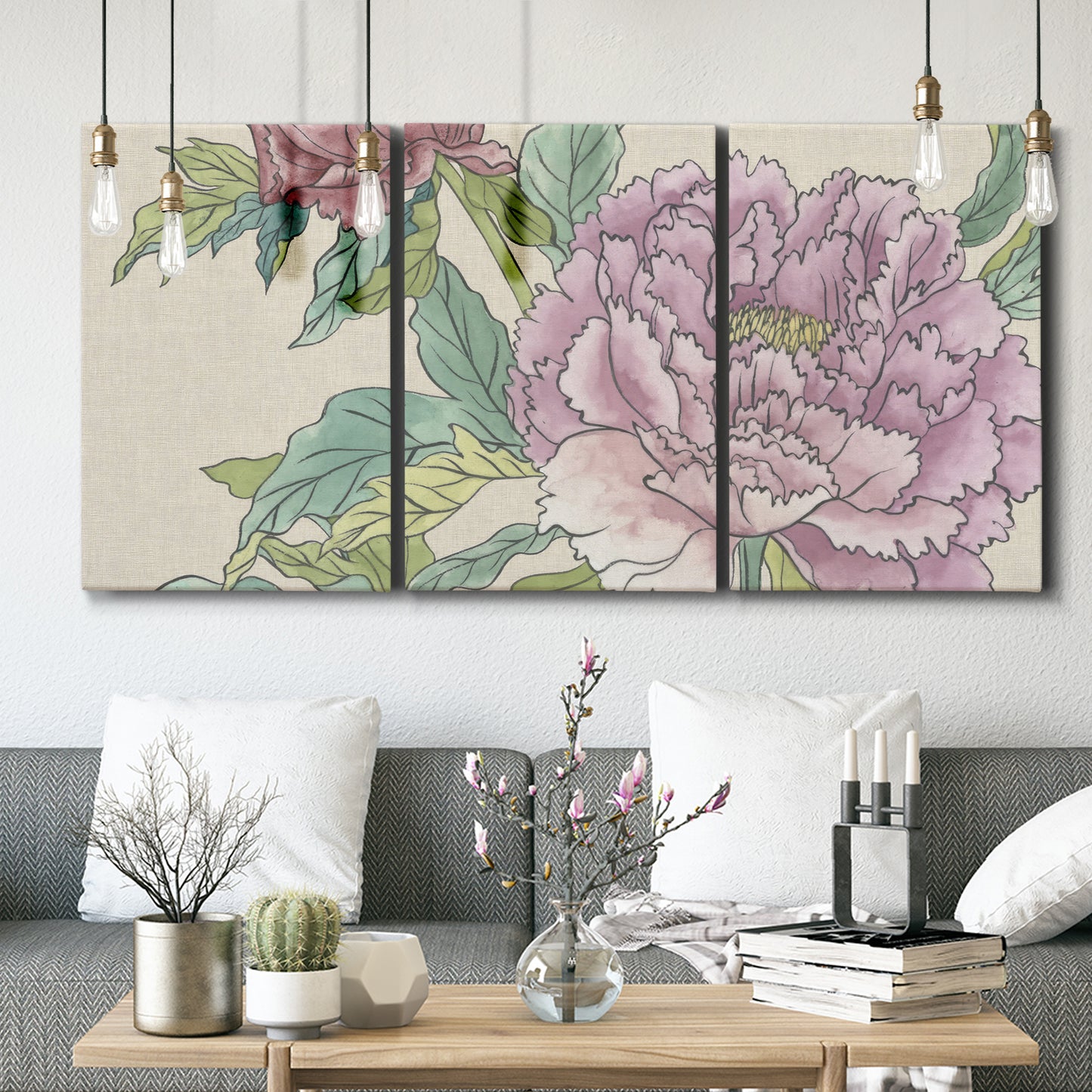 Three-panel canvas wall art featuring soft pink peony blossoms, displayed in a modern living room above seating.