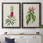 Set of two black barnwood framed canvas prints depicting a coordinated art pair of pink flowering plant specimens rendered as vintage botanical plate illustrations above a dining room sideboard.