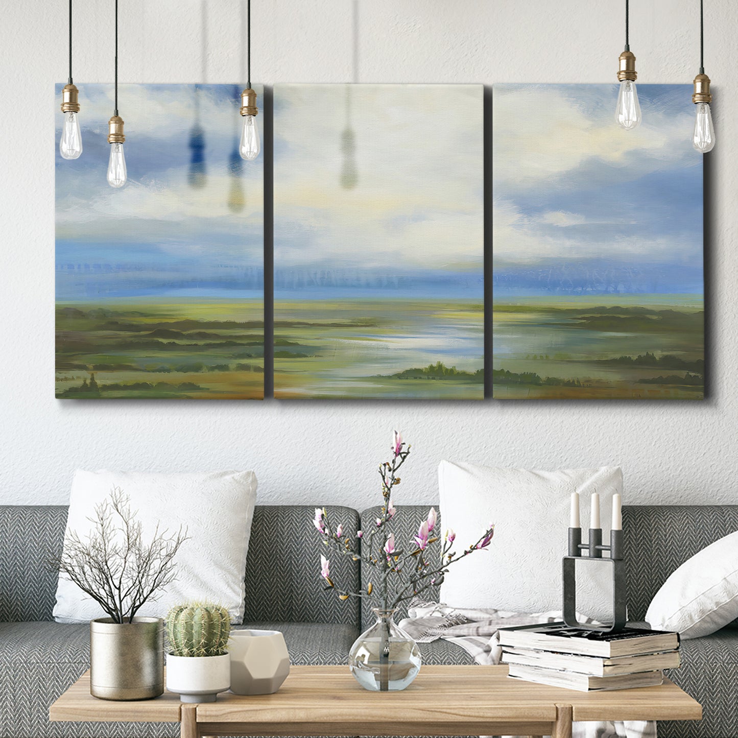 Three-panel canvas wall art featuring pastoral path leading into distance, displayed in a modern living room above seating.