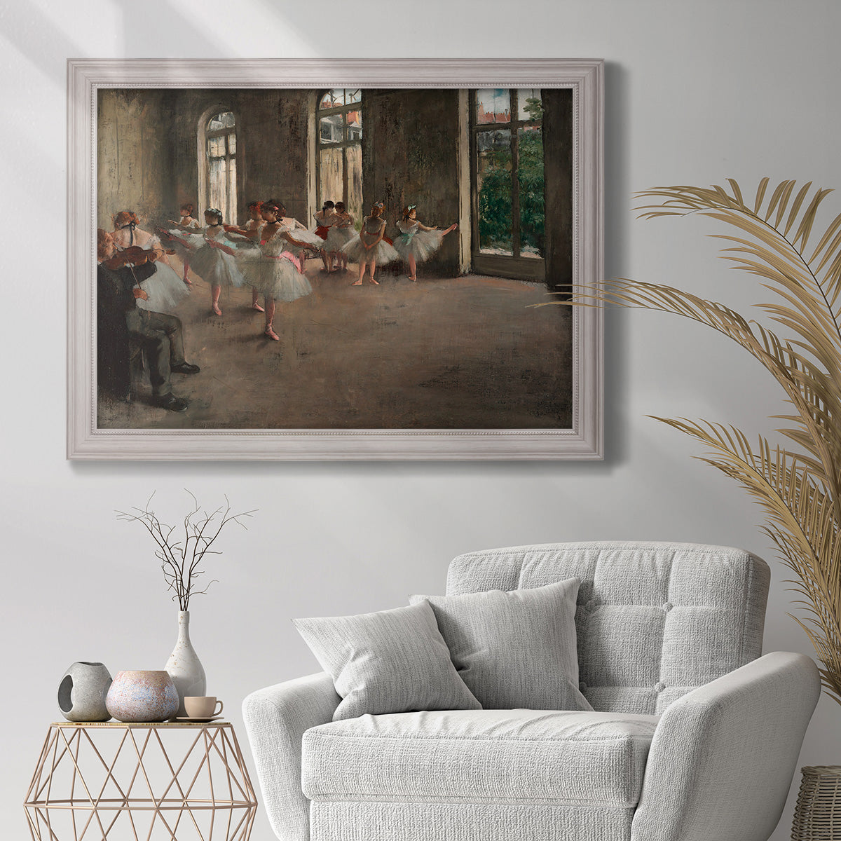 Early impressionist ballet rehearsal painting by Edgar Degas in an ornate weathered white frame displayed in a bright interior setting.