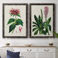 Set of two black barnwood framed canvas prints depicting a coordinated art pair of colorful flowering plant specimens rendered as antique botanical plate illustrations above a dining room sideboard.