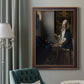 Quiet interior genre scene of a woman with scales by Johannes Vermeer in an ornate bronzed mahogany wood frame displayed in a dark-toned interior setting.