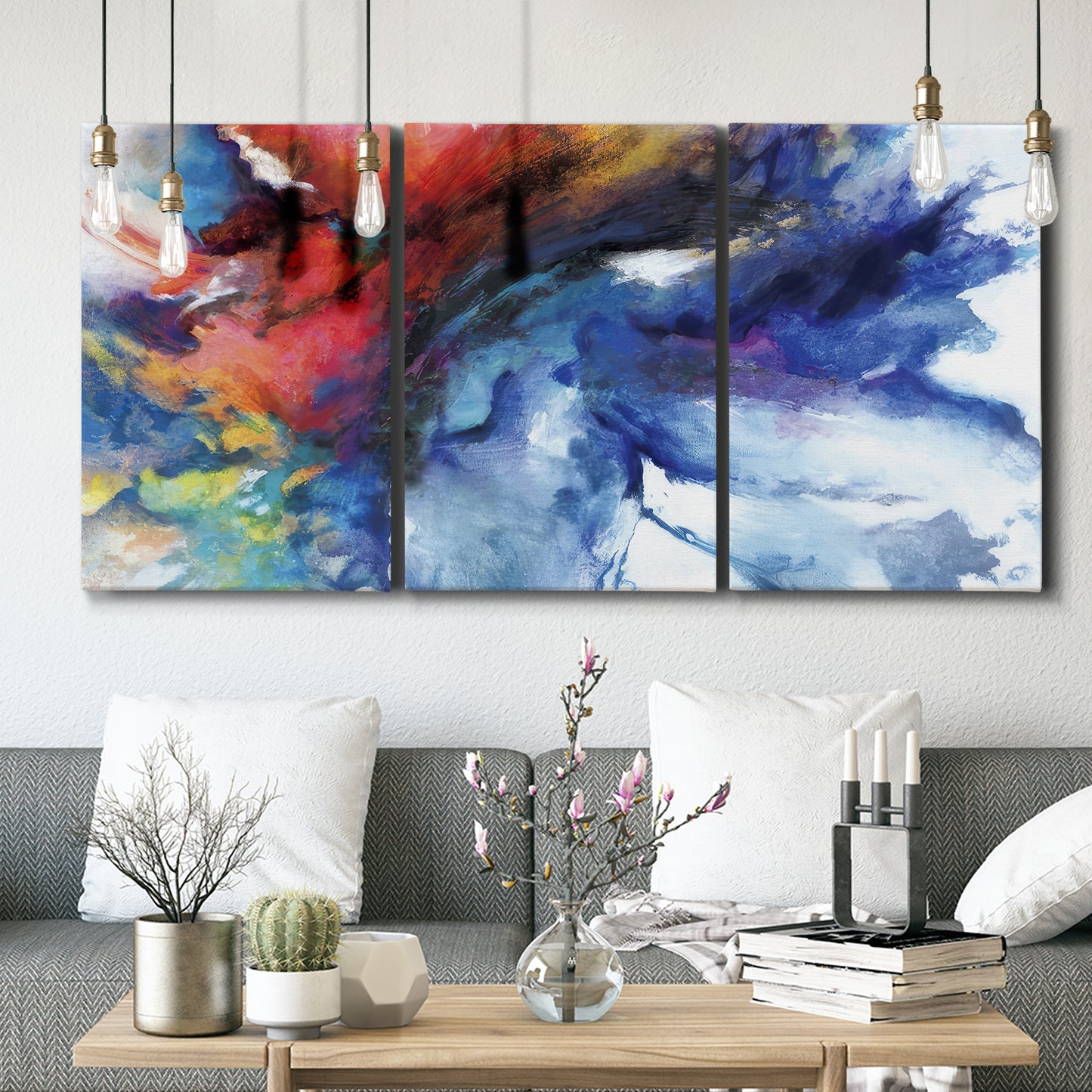 Three-panel canvas wall art featuring vibrant abstract color explosion, displayed in a modern living room above seating.
