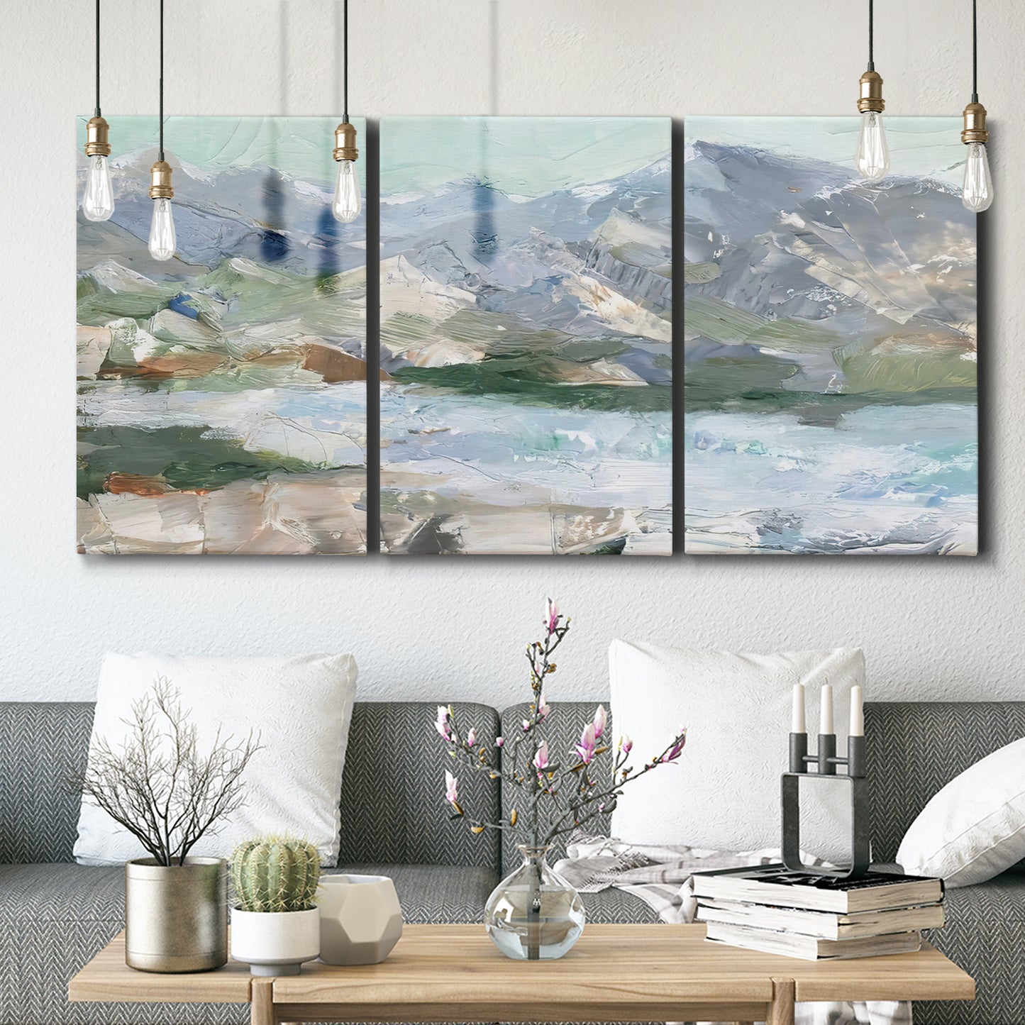 Three-panel canvas wall art featuring pastel mountain landscape view, displayed in a modern living room above seating.