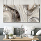 Three-panel canvas wall art featuring layered stone inspired abstract forms, displayed in a modern living room above seating.