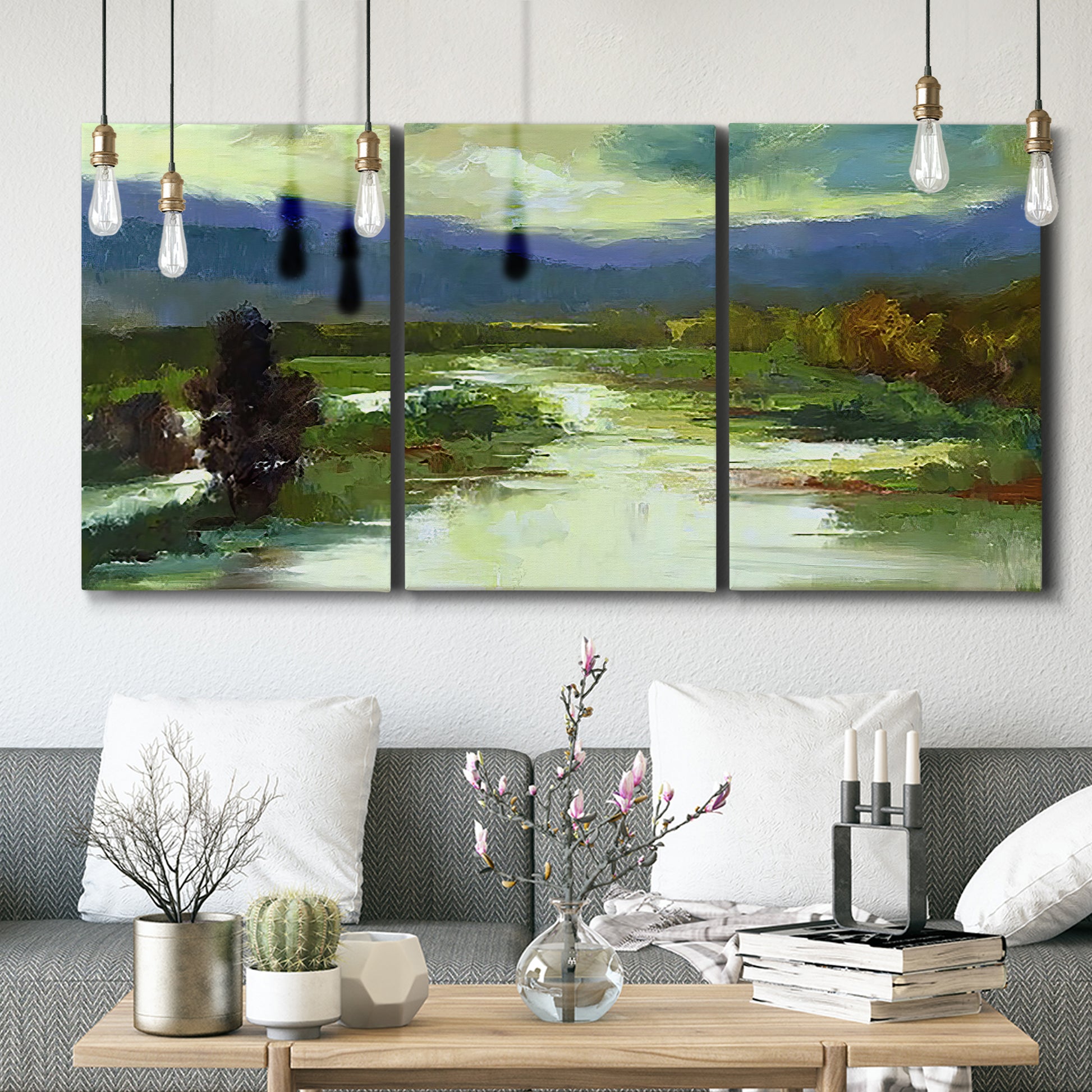 Three-panel canvas wall art featuring open meadow landscape with distant hills, displayed in a modern living room above seating.