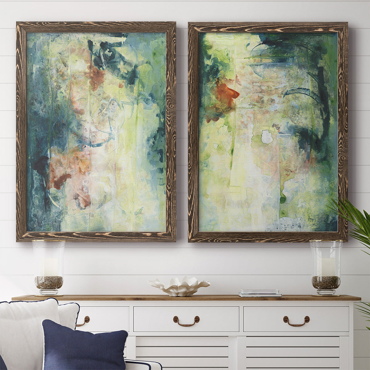 Set of two walnut barnwood framed canvas prints depicting a coordinated art pair of layered blue green cream and charcoal textures rendered as nature-inspired mixed-media abstracts above a dining room sideboard.