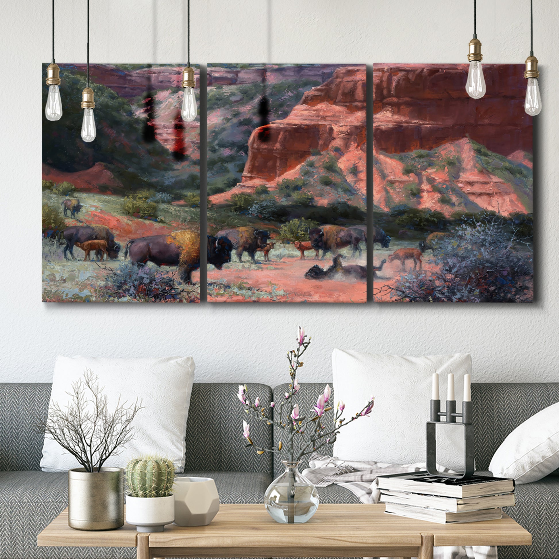 Three-panel canvas wall art featuring rugged canyon landscape with wildlife, displayed in a modern living room above seating.