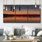 Three-panel canvas wall art featuring glowing sunset over water, displayed in a modern living room above seating.