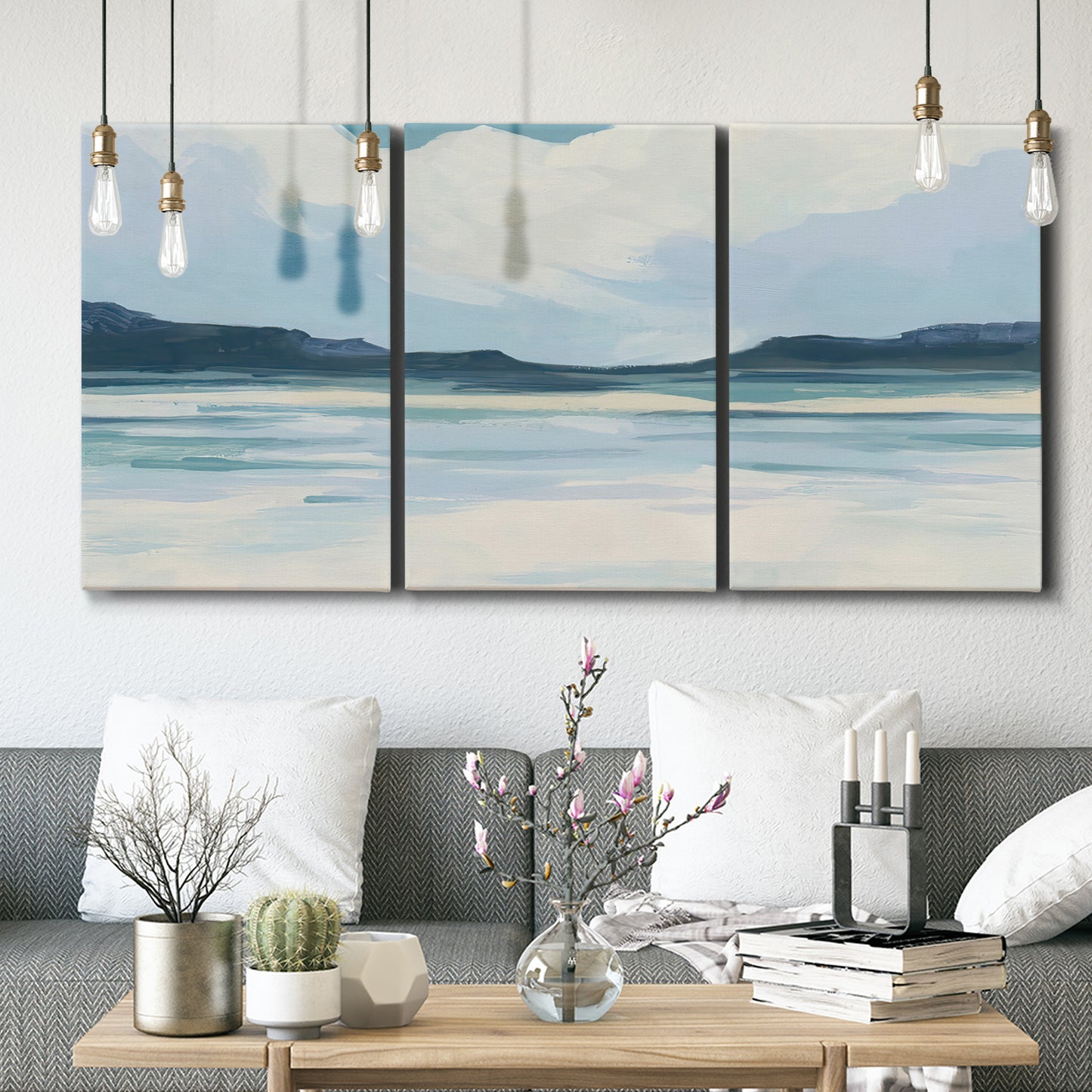 Three-panel canvas wall art featuring soft coastal shoreline landscape, displayed in a modern living room above seating.