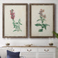 Set of two walnut barnwood framed canvas prints depicting antique floral illustrations featuring a tall red bloom and a clustered mauve flower above a dining room sideboard.