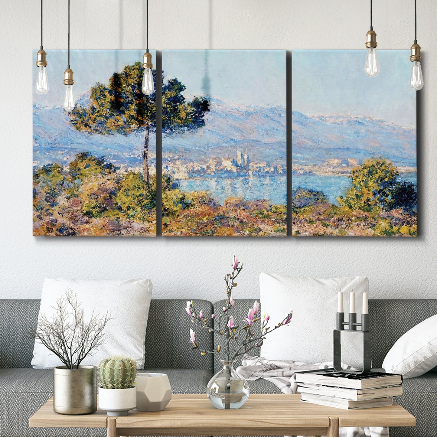 Three-panel canvas wall art featuring coastal town viewed from hillside, displayed in a modern living room above seating.