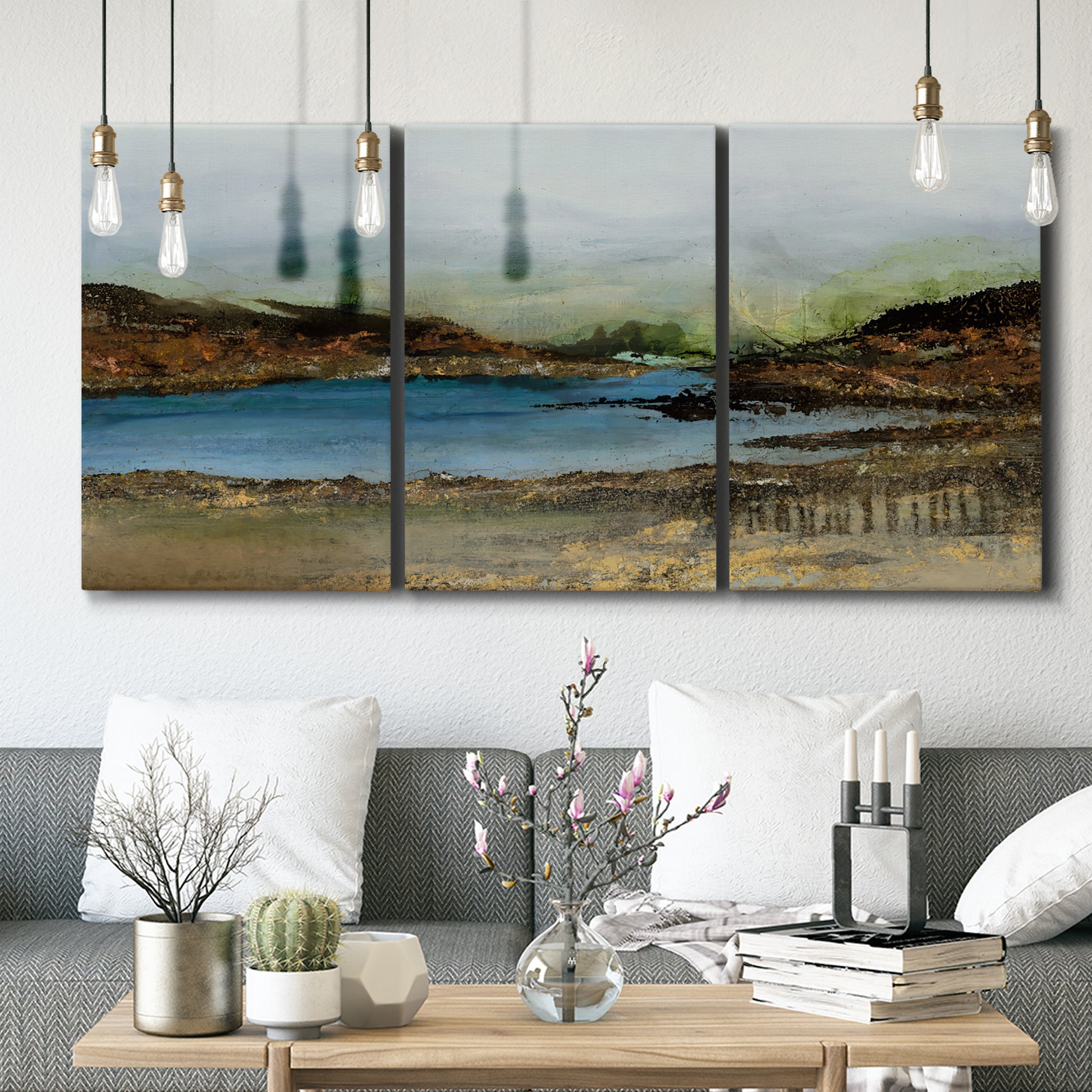 Three-panel canvas wall art featuring peaceful lakeside shoreline landscape, displayed in a modern living room above seating.
