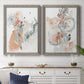 Set of two gray barnwood framed canvas prints depicting a coordinated art pair of loose blush gray and coral floral gestures rendered as abstract watercolor botanicals above a dining room sideboard.