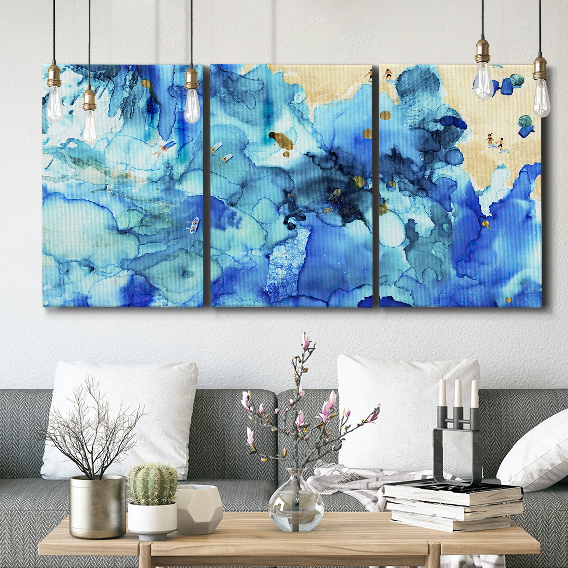 Three-panel canvas wall art featuring abstract coastal beach color fields, displayed in a modern living room above seating.