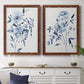 Set of two maple barnwood framed canvas prints depicting a coordinated art pair of loose blue flowers and leafy branches rendered as expressive watercolor botanical paintings above a dining room sideboard.