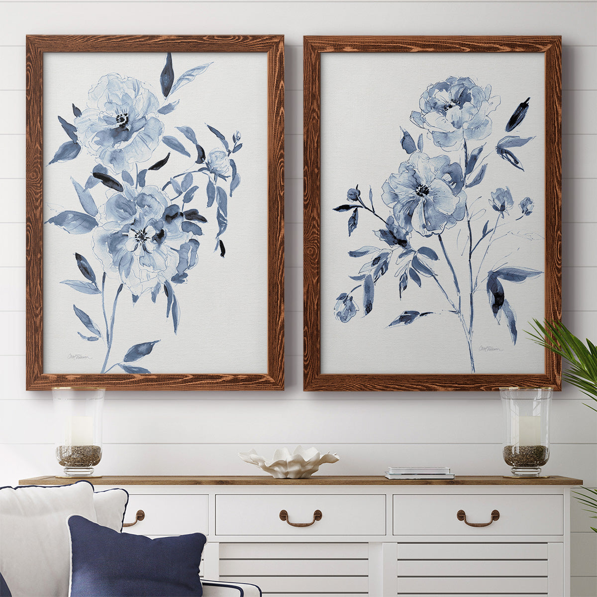 Set of two maple barnwood framed canvas prints depicting a coordinated art pair of loose blue flowers and leafy branches rendered as expressive watercolor botanical paintings above a dining room sideboard.