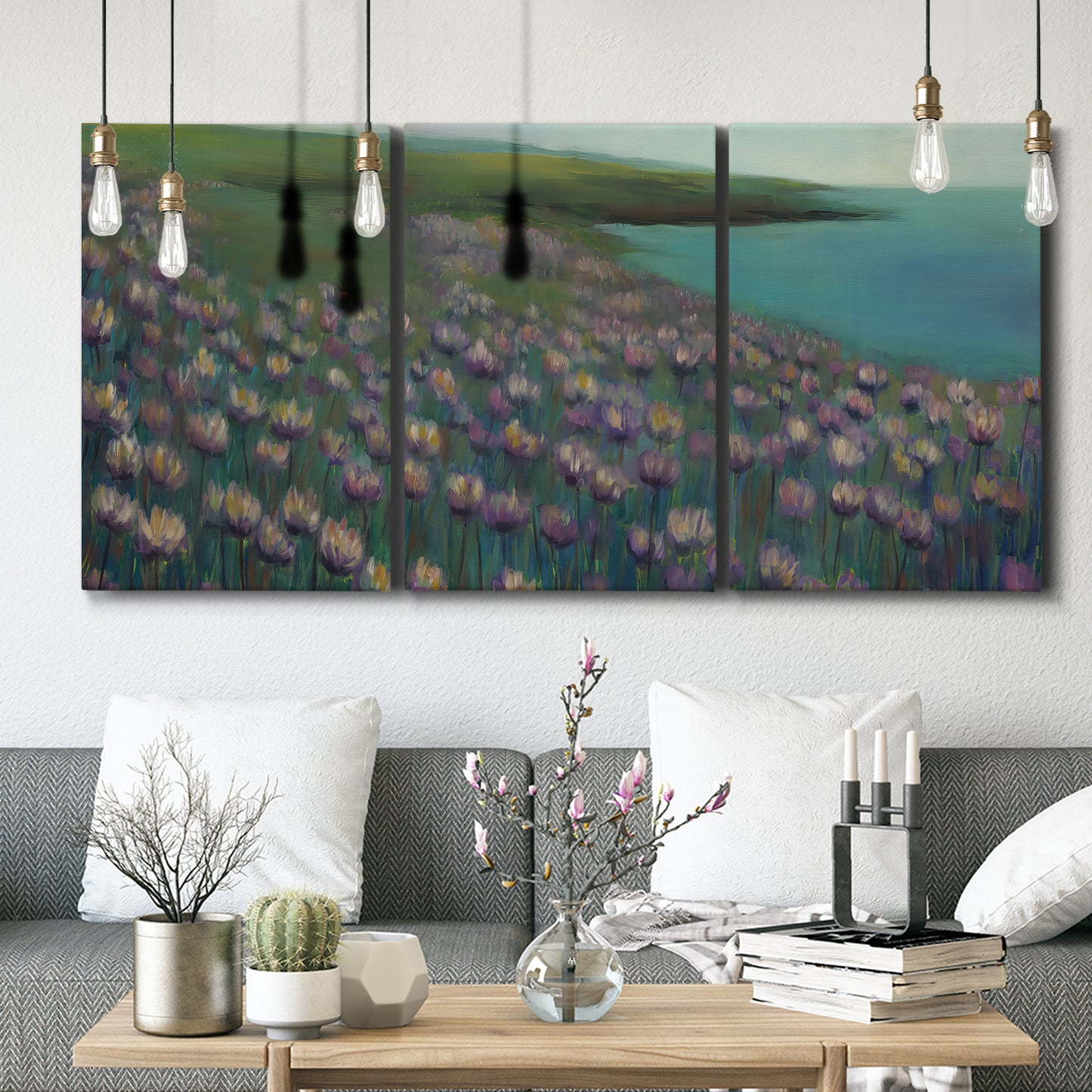Three-panel canvas wall art featuring calm coastal landscape sanctuary, displayed in a modern living room above seating.