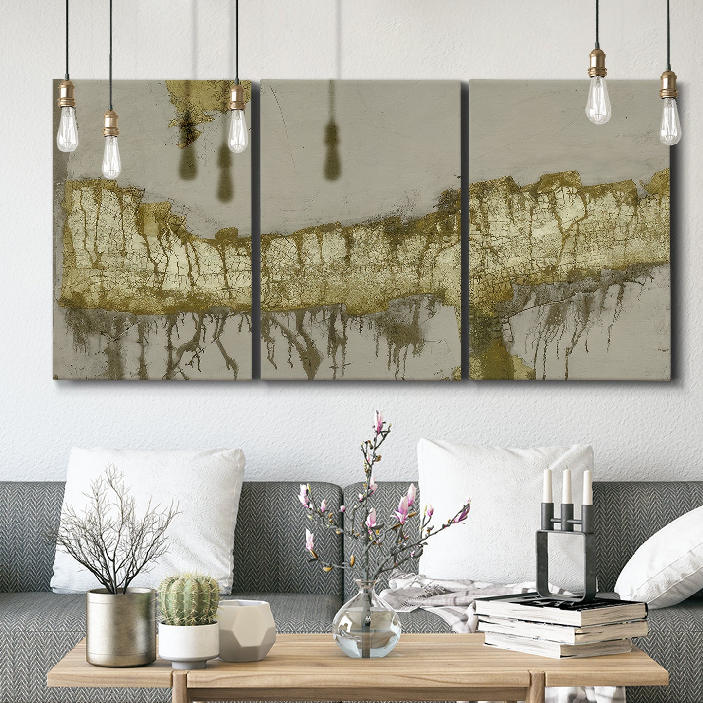 Three-panel canvas wall art featuring gold accented abstract ravine, displayed in a modern living room above seating.