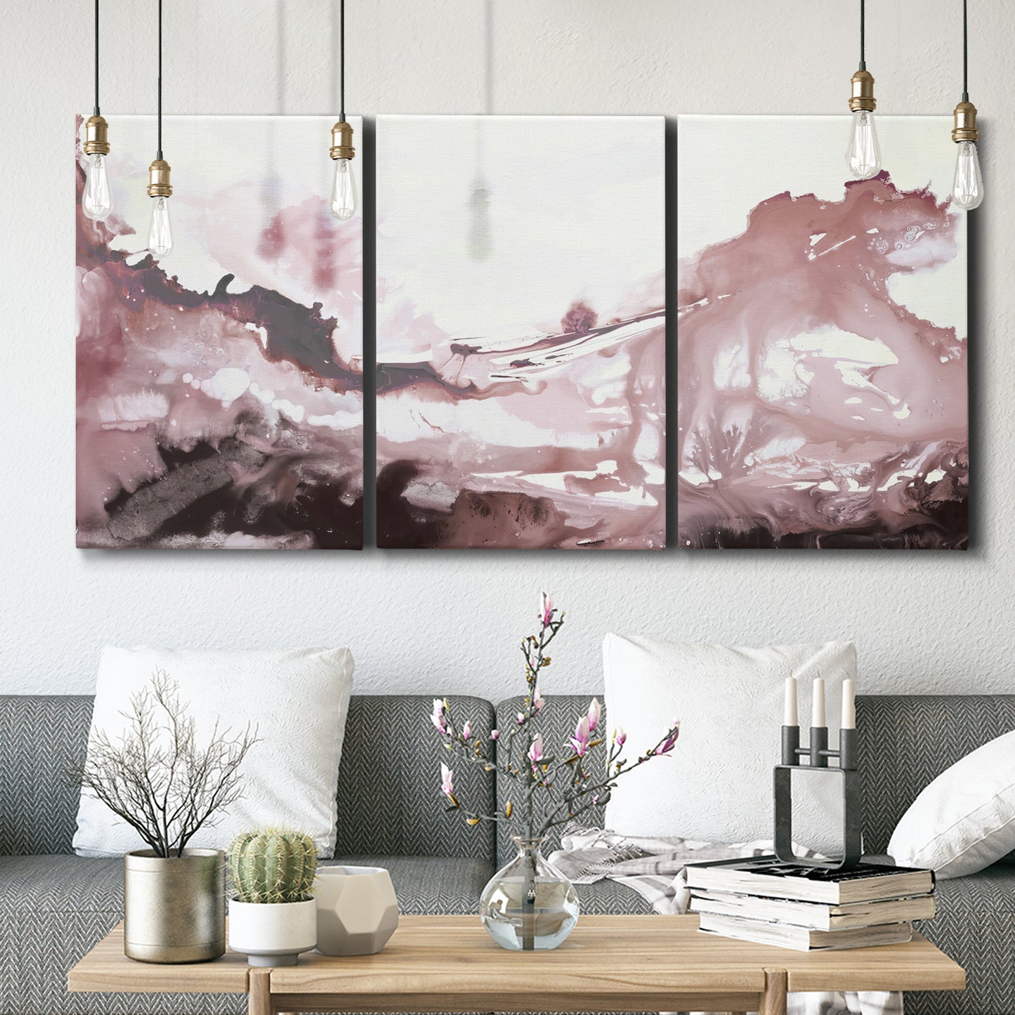 Three-panel canvas wall art featuring soft pink abstract scenic layers, displayed in a modern living room above seating.