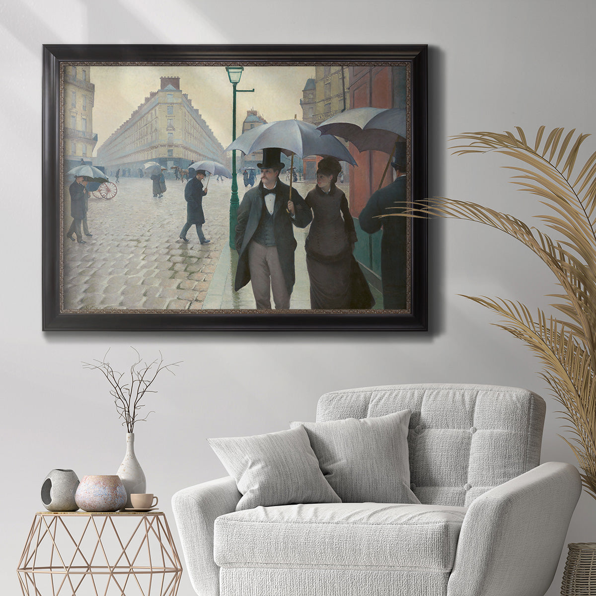 Impressionist urban street scene in the rain by Gustave Caillebotte in an ornate black frame with gilded inner detail displayed in a bright interior setting.