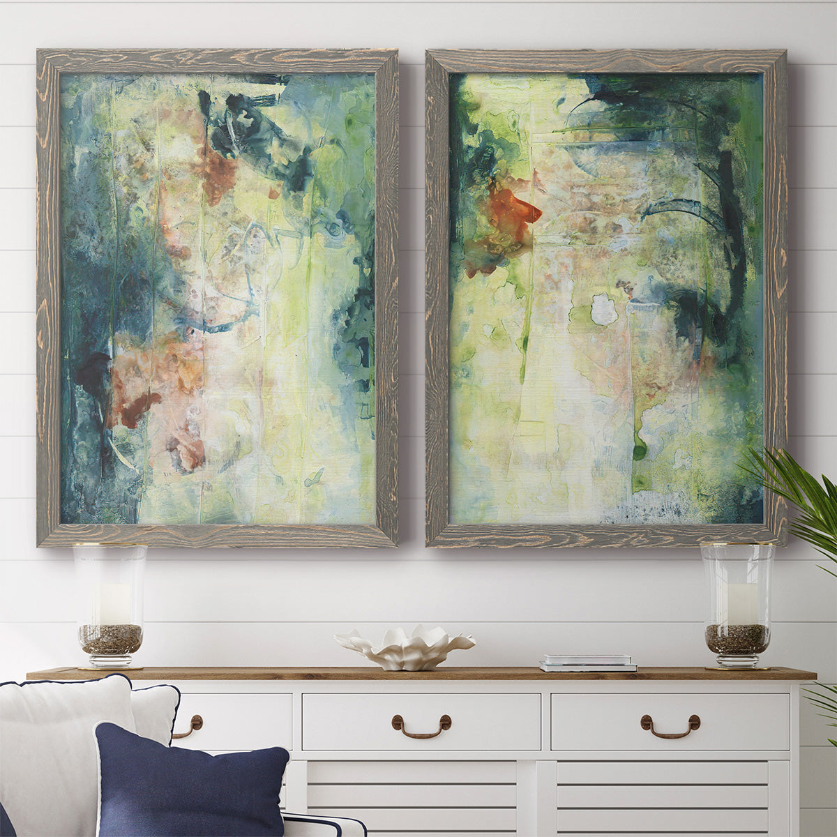 Set of two gray barnwood framed canvas prints depicting a coordinated art pair of layered blue green cream and charcoal textures rendered as nature-inspired mixed-media abstracts above a dining room sideboard.