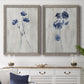 Set of two gray barnwood framed canvas prints depicting a coordinated art pair of blue wildflower stems on weathered neutral paper rendered as rustic monochrome botanical paintings above a dining room sideboard.