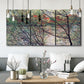 Three-panel canvas wall art featuring riverside park with figures and trees, displayed in a modern living room above seating.