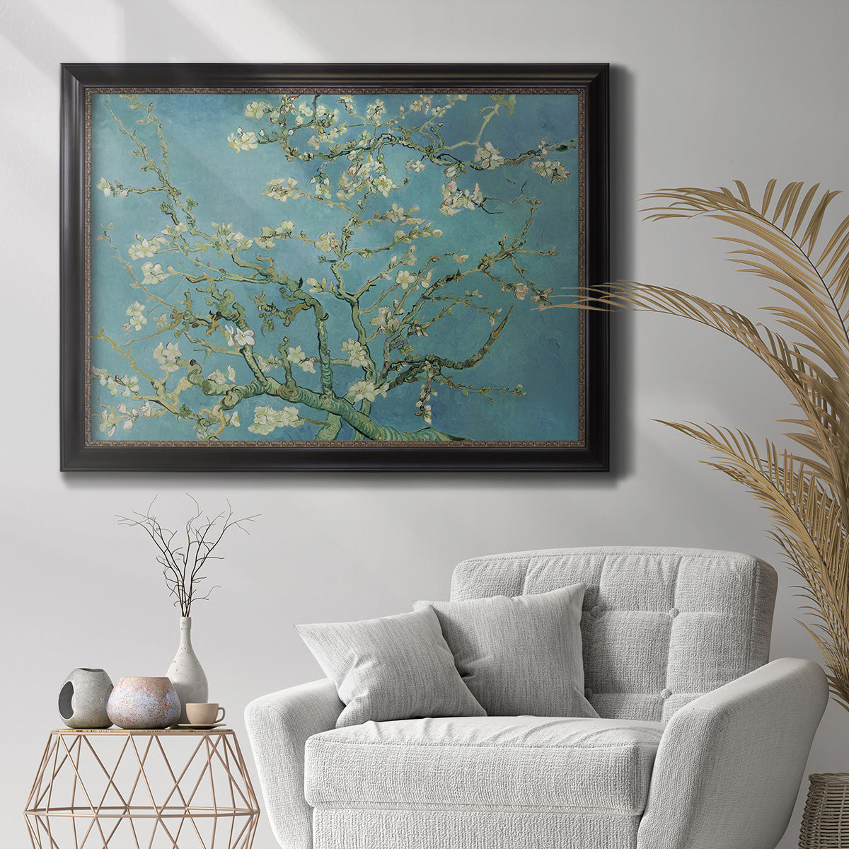Impressionist flowering almond branch painting by Vincent van Gogh in an ornate black frame with gilded inner detail displayed in a bright interior setting.