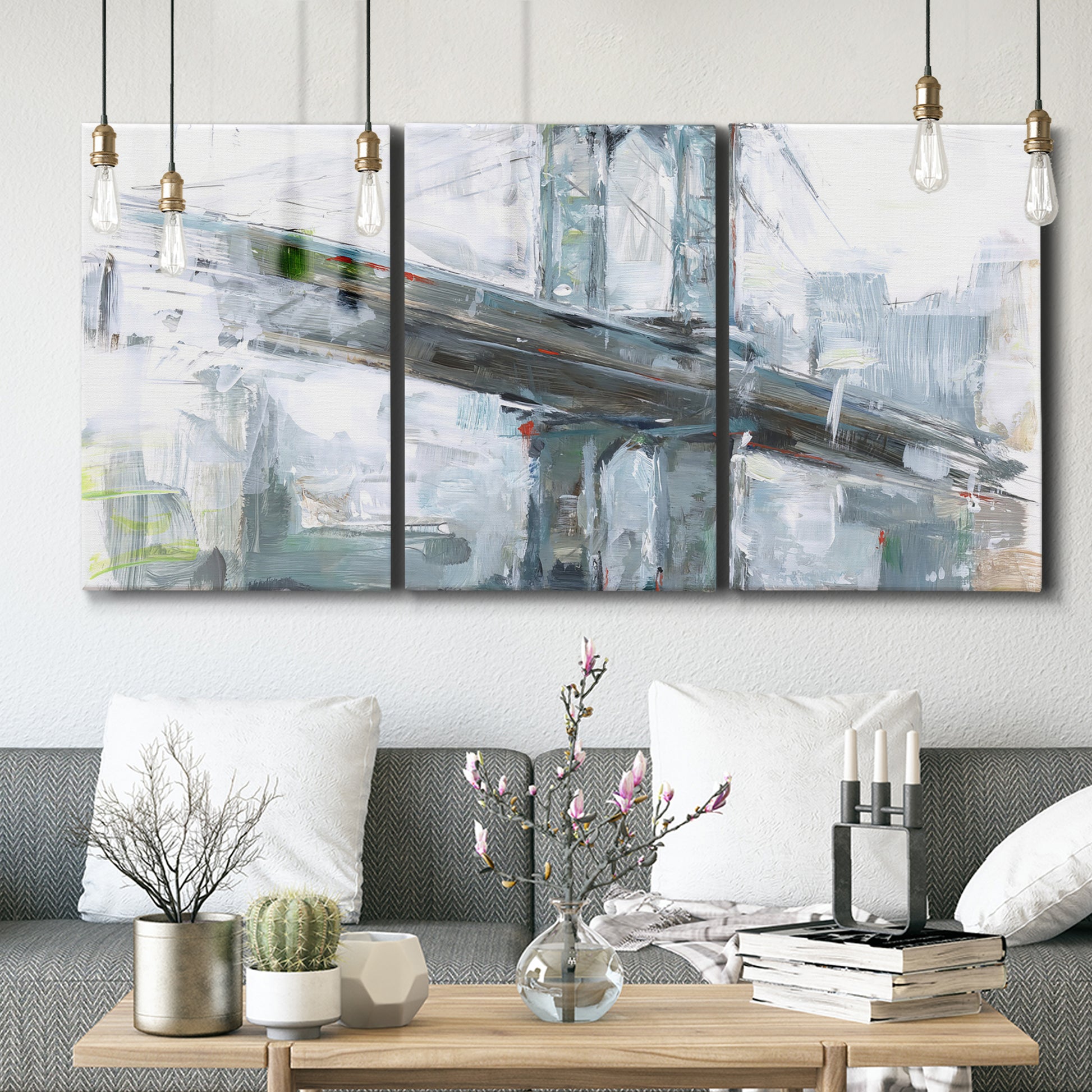 Three-panel canvas wall art featuring urban cityscape with architectural forms, displayed in a modern living room above seating.
