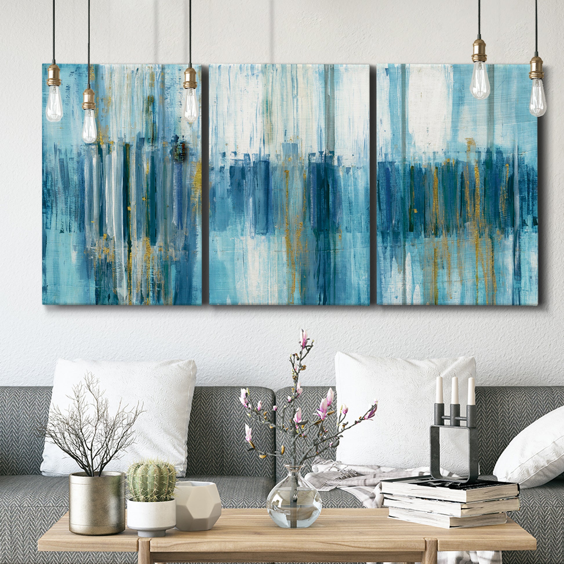 Three-panel canvas wall art featuring layered abstract earth tones, displayed in a modern living room above seating.