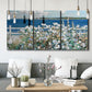 Three-panel canvas wall art featuring coastal garden overlooking bay, displayed in a modern living room above seating.