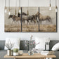 Three-panel canvas wall art featuring wild horses roaming open terrain, displayed in a modern living room above seating.