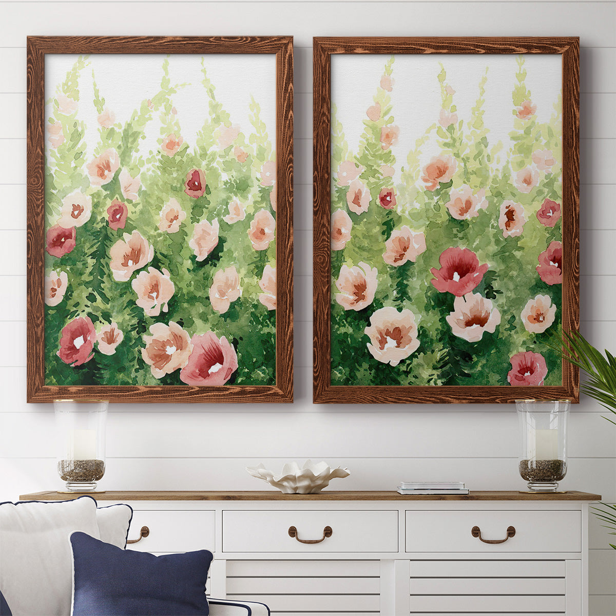 Set of two maple barnwood framed canvas prints depicting a coordinated art pair of a field of pink coral and white flowers rendered as luminous impressionistic floral paintings above a dining room sideboard.