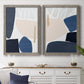Set of two gray barnwood framed canvas prints depicting a coordinated art pair of large navy cream and beige organic geometric shapes rendered as minimalist color-block abstracts above a dining room sideboard.